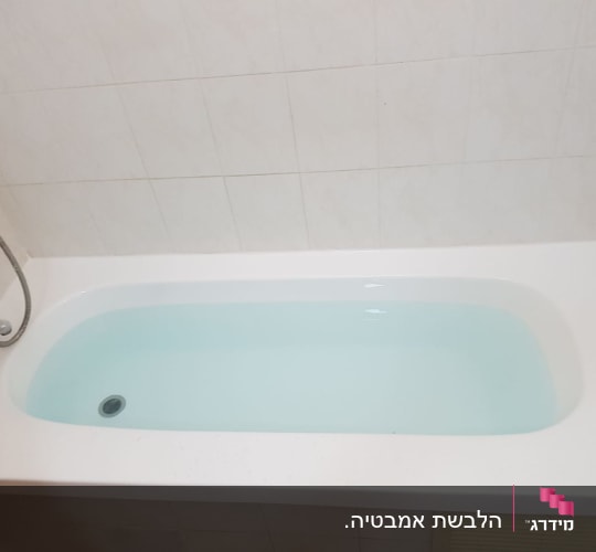 אמבטיה לבנה עם מים, ברז ומקלחת יד